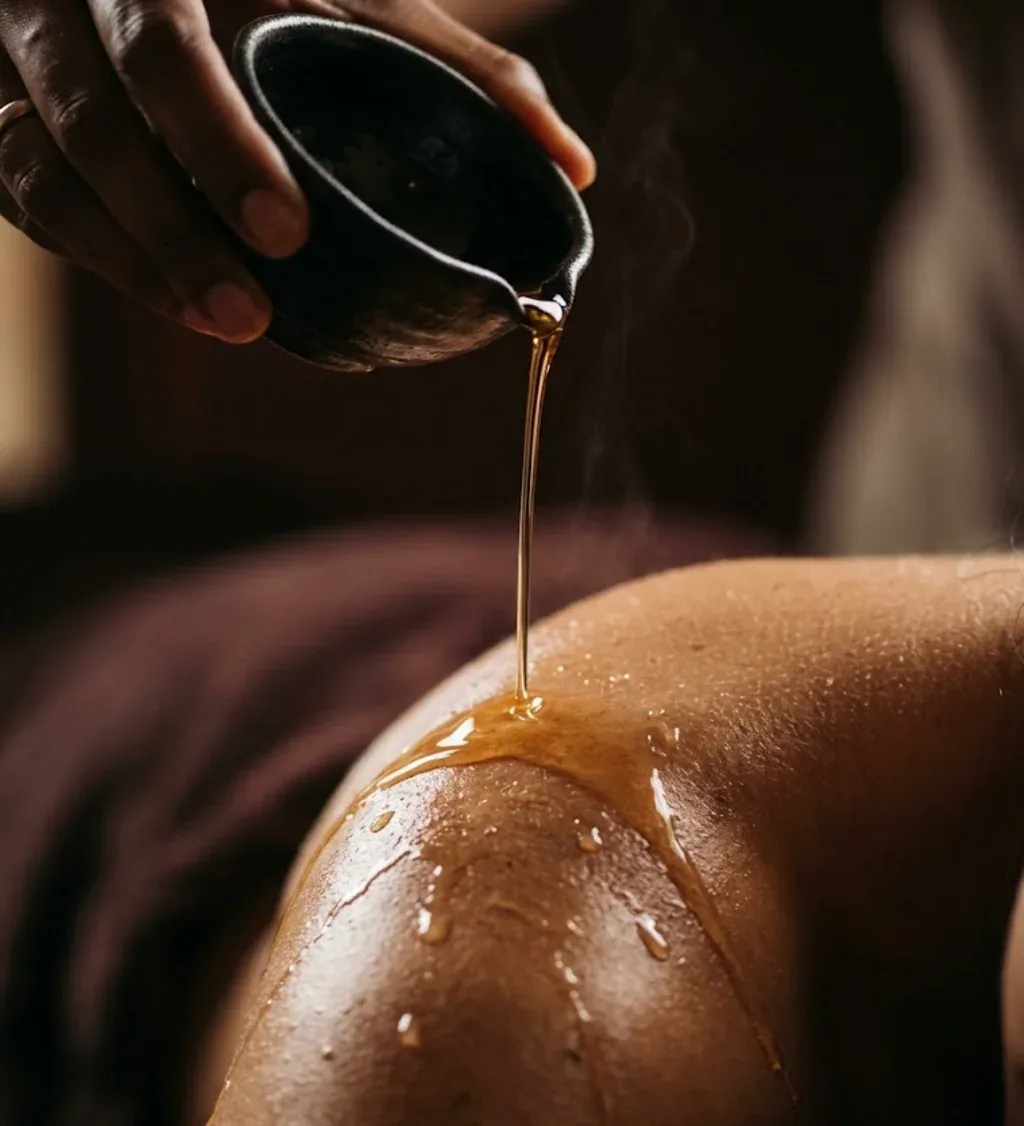 Huile chaude versée sur l’épaule lors d’un massage